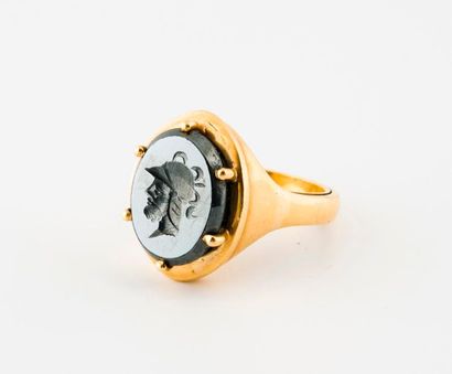 null Yellow gold (750) ring in ring centred on an oval hematite intaglio engraved...