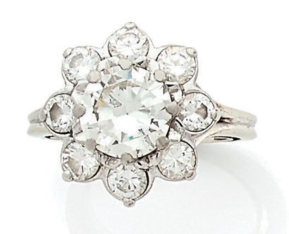 null Bague fleur en platine (850) centrée d'un diamant demi-taille dans un entourage...