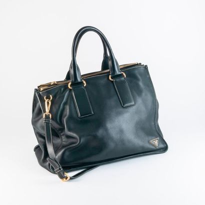 PRADA 

Grand sac en cuir lisse noir à deux soufflets zippés. 

Garniture en métal...