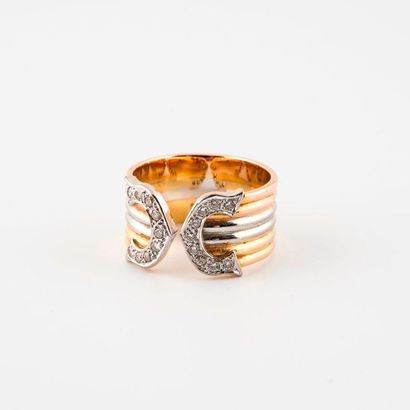 null Three-tone (750) gold band ring, gadrooned, with a decoration of two clasping...