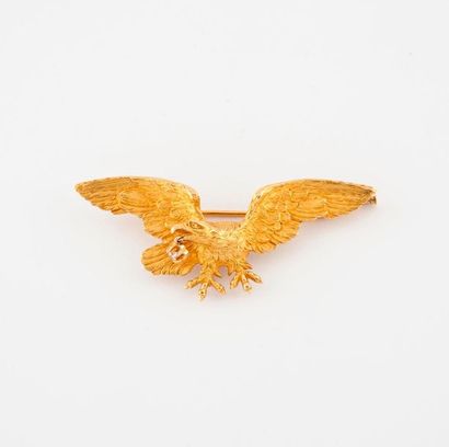 null Broche en or jaune (750) figurant un aigle aux ailes deployées retenant dans...