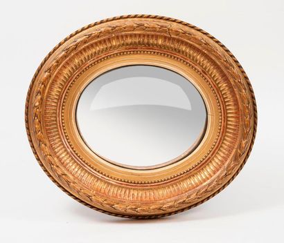 null Small oval shaped witch mirror with a gilded wooden and plaster frame decorated...
