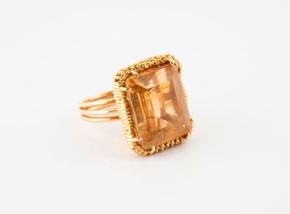 null Ring with twisted yellow gold (750) strings holding between four claws a rectangular...
