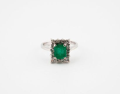 null A white gold ring (750) centered by a rectangular emerald in a setting of small...