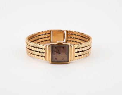 LONGINES Lady's bracelet watch in yellow gold (750). 
 Curved square case. 
Copper-plated...