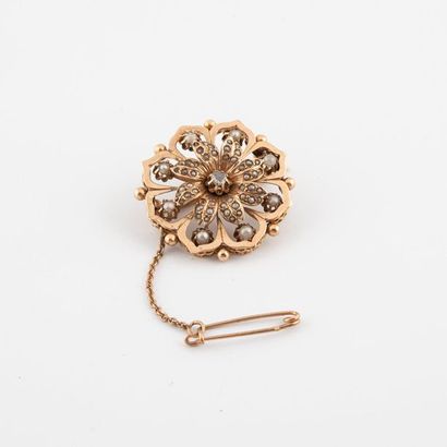 null Broche circulaire en or jaune (750) figurant une fleur centrée d'un petit diamant...