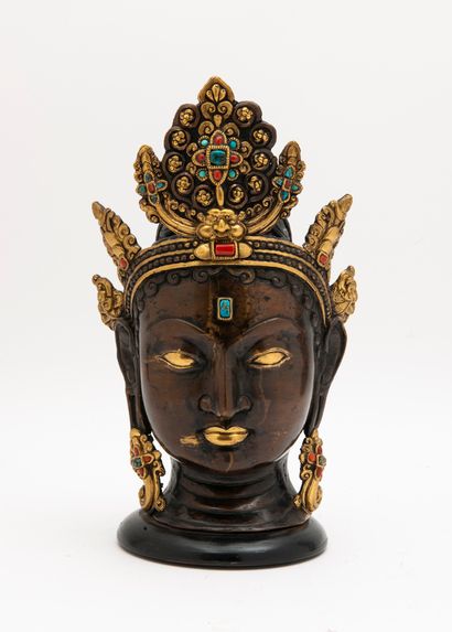 TIBET, XXème siècle Head of Buddha with bun and tiara in patinated and gilded bronze,...