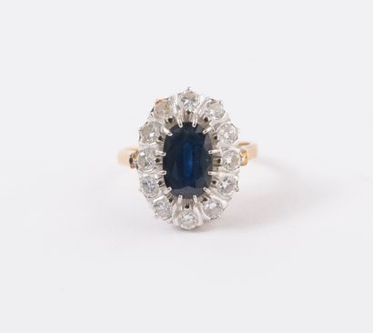 null Yellow gold (750) daisy ring centered on an oval faceted sapphire in a claw...