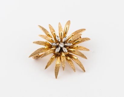 null Flower brooch in textured yellow gold (750), centered with small brilliant-cut...