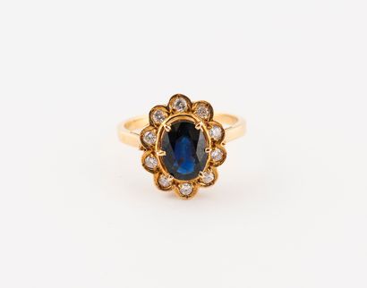 null Yellow gold (750) ring set with a faceted oval sapphire in a claw setting, surrounded...