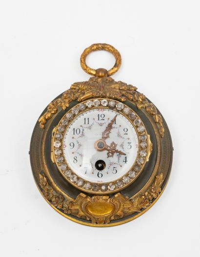 null 
Two small alcove labels:




One in gilt bronze, the enamel dial with a winding...