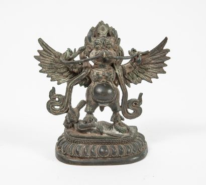 ASIE, début du XXème siècle Garuda, half-man, half-bird deity, biting a snake. Semi-oval...