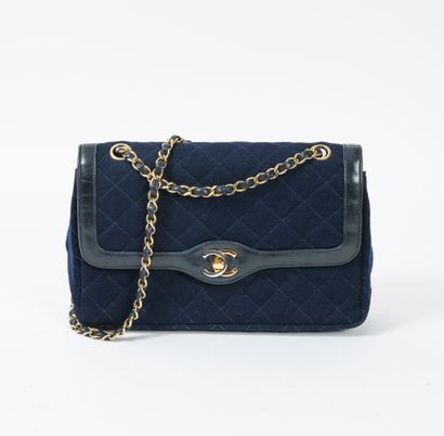 CHANEL Double flap bag in navy blue jersey and lambskin.

Red lambskin lining.

Adjustable...