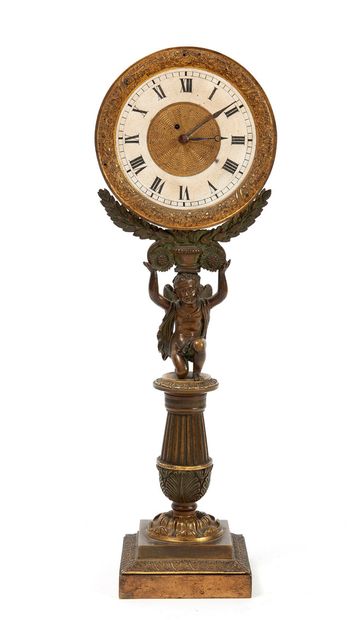 null 
A bronze and brass CLOCKWORK, the annular dial in frosted glass carried by...