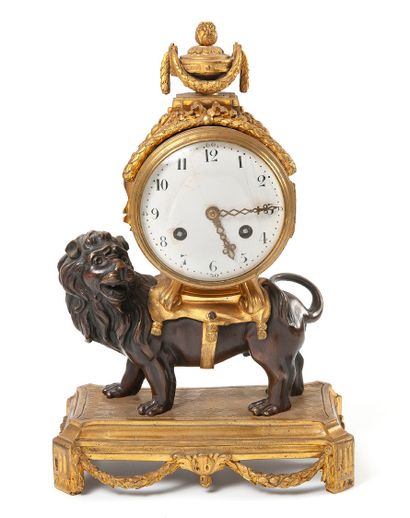 null 
LION CLOCK In gilt bronze and patina, the case surmounted by a cassolette....