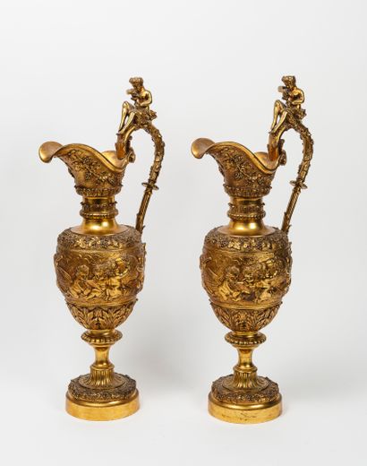 null A pair of decorative ormolu ewers with ovoid body on a circular pedestal, with...