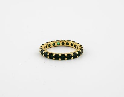 null American wedding band in yellow gold (750) set with round faceted emeralds....
