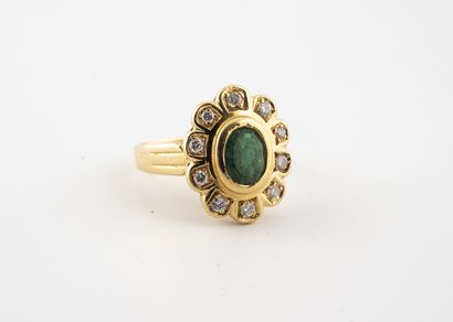 null Yellow gold (750) daisy ring centered on an oval faceted emerald set in brilliant-cut...