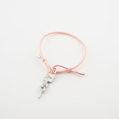 DIOR Bracelet formé d'un élastique rose retenant un motif de cadenas avec deux clés...