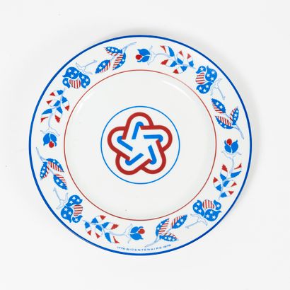 CHRISTIAN DIOR PARIS Assiette en porcelaine blanche à décor en bleu et rouge d'une...