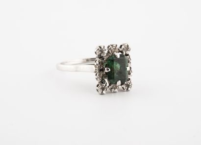 null A white gold (750) ring centered on a square green stone in a setting of eight-eighths...