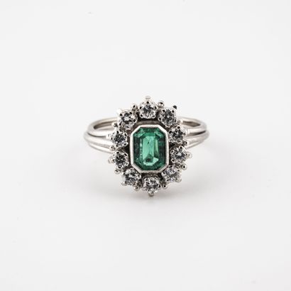 null A white gold (750) filigree ring centered on a rectangular cut emerald in a...