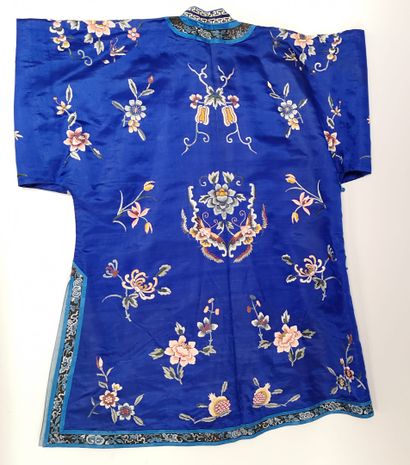 CHINE, début du XXème siècle - Tunique en soie bleue brodée de motifs floraux et...