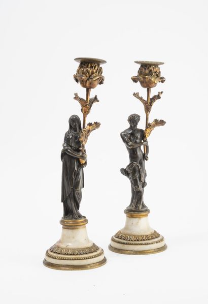 null 
Pair of chased bronze and gilt bronze torches with circular white marble bases...