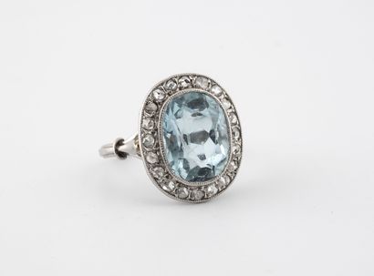 null A platinum (850) ring centered on an oval faceted aquamarine in a beaded setting...