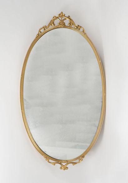 null A gilt brass framed oval mirror decorated with palmettes and a frieze of pearls.

Late...