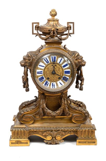 null A gilt bronze clock with a circular case framed by lions' heads with mobile...