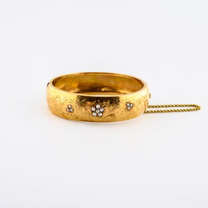 null Bracelet jonc ouvrant en or jaune (750) à motifs de fleurs ciselées et ornées...