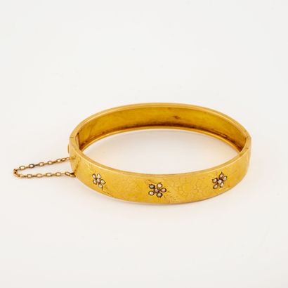 null Bracelet jonc ouvrant en or jaune (750) à motif écaille ciselé et orné de semences...