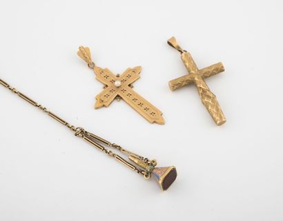 Lot comprenant : - Two cross pendants in yellow gold (750), one decorated with a...
