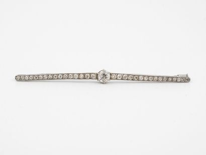 null Platinum (850) barrette brooch centered on a claw-set half-cut diamond and flanked...