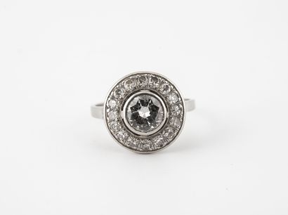 null A round platinum ring (850) centered on a half-cut diamond in a closed setting,...