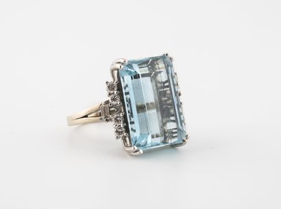 null Yellow gold (750) ring centered on a large faceted emerald-cut aquamarine set...