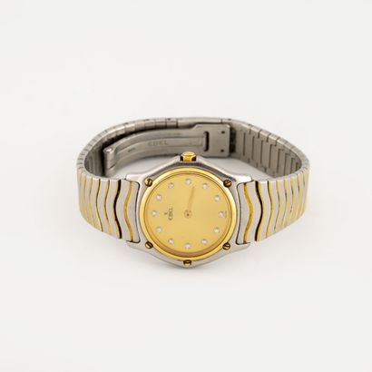 EBEL Lady's wrist watch in brushed steel and gold.

Round case.

Dial with gilded...