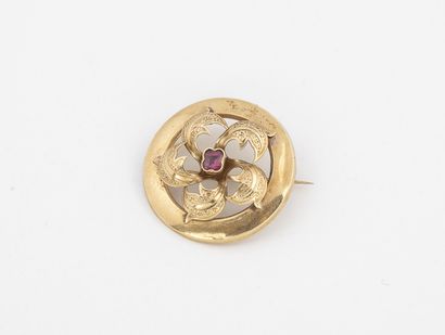 null Yellow gold (750) round brooch with openwork flower motif, centered with a faceted...