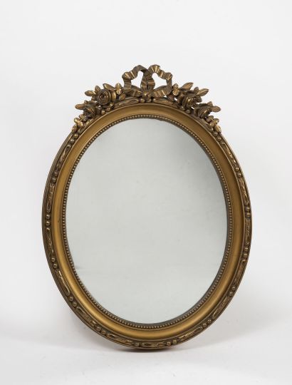 null Miroir ovale en bois sculpté doré ajouré à décor de fleurs et d'un noeud de...