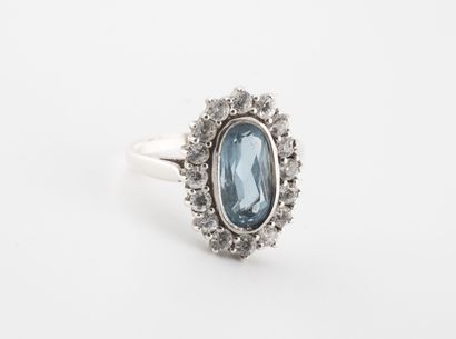 null 
Silver daisy ring (min. 800) with oval bezel centered on a faceted oval blue...