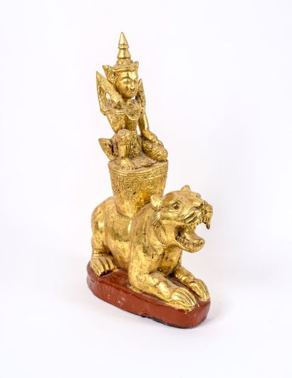 THAILANDE, Xxème siècle Divinity riding a tiger. 

Gilded wood sculpture on a painted...