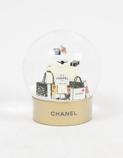 CHANEL Beauté Boule à neige à motif, sous globe, d'un flacon n°5 et de sacs griffés.

Base...