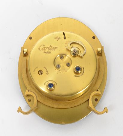 CARTIER Paris Oval alarm clock in gilt metal, the bezel enamelled black.

White enamelled...