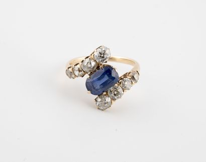 null Yellow gold (750) ring centered on an oval (?) faceted sapphire, set with two...