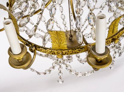 null A gilded bronze and brass eight-light chandelier with facetted colorless glass...