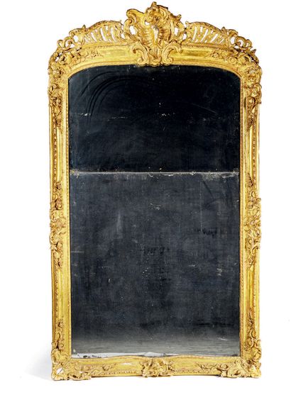  Large gilded wood mantel mirror molded and carved with a rocaille decoration of...