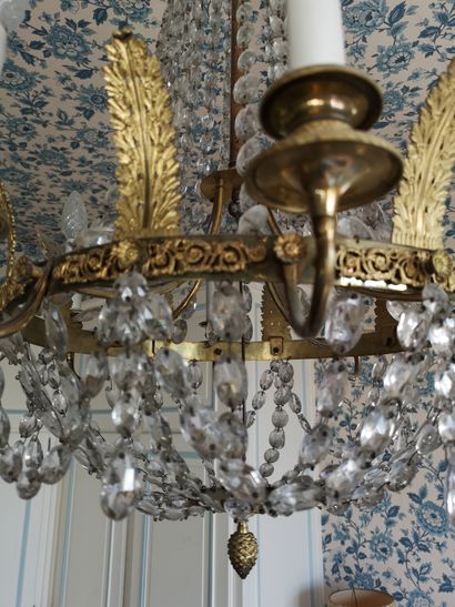 null A gilded bronze and brass eight-light chandelier with facetted colorless glass...