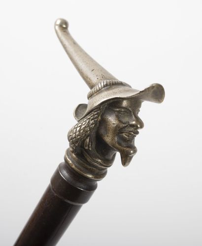 null Wooden cane with its silver-plated bronze knob featuring a man with a pointed...