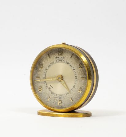 JAEGER Round travel alarm clock of oval form posing on a gilded metal base.

Circular...